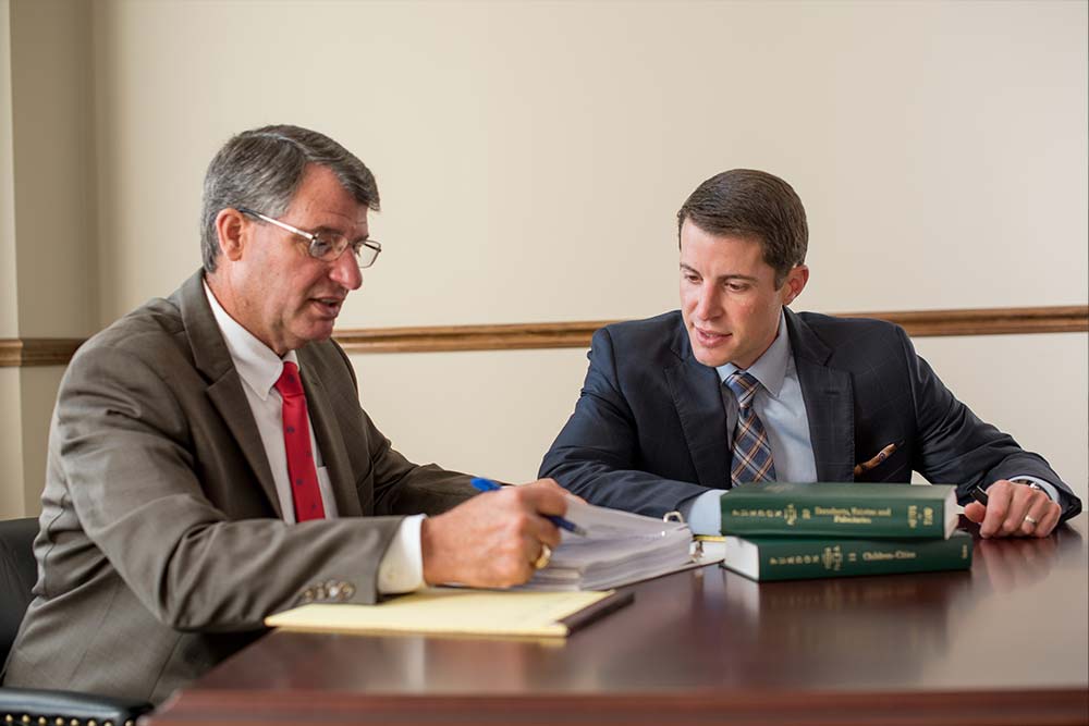 Two Attorneys Reviewing Notes At A Table