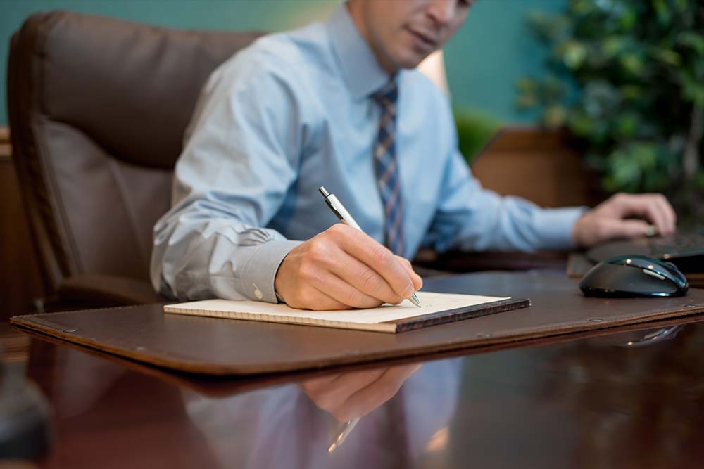 Attorney Writing Notes At Desk